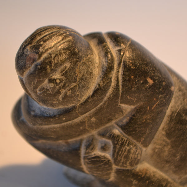 Inuit carving small hunter pulling seal from hole