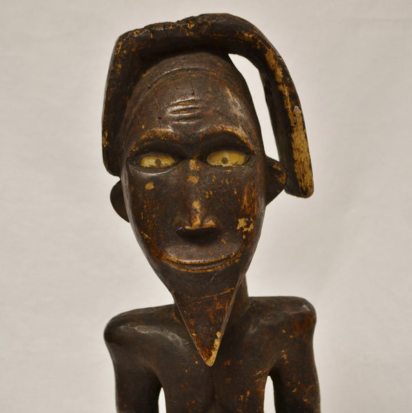 Nude African man carving face